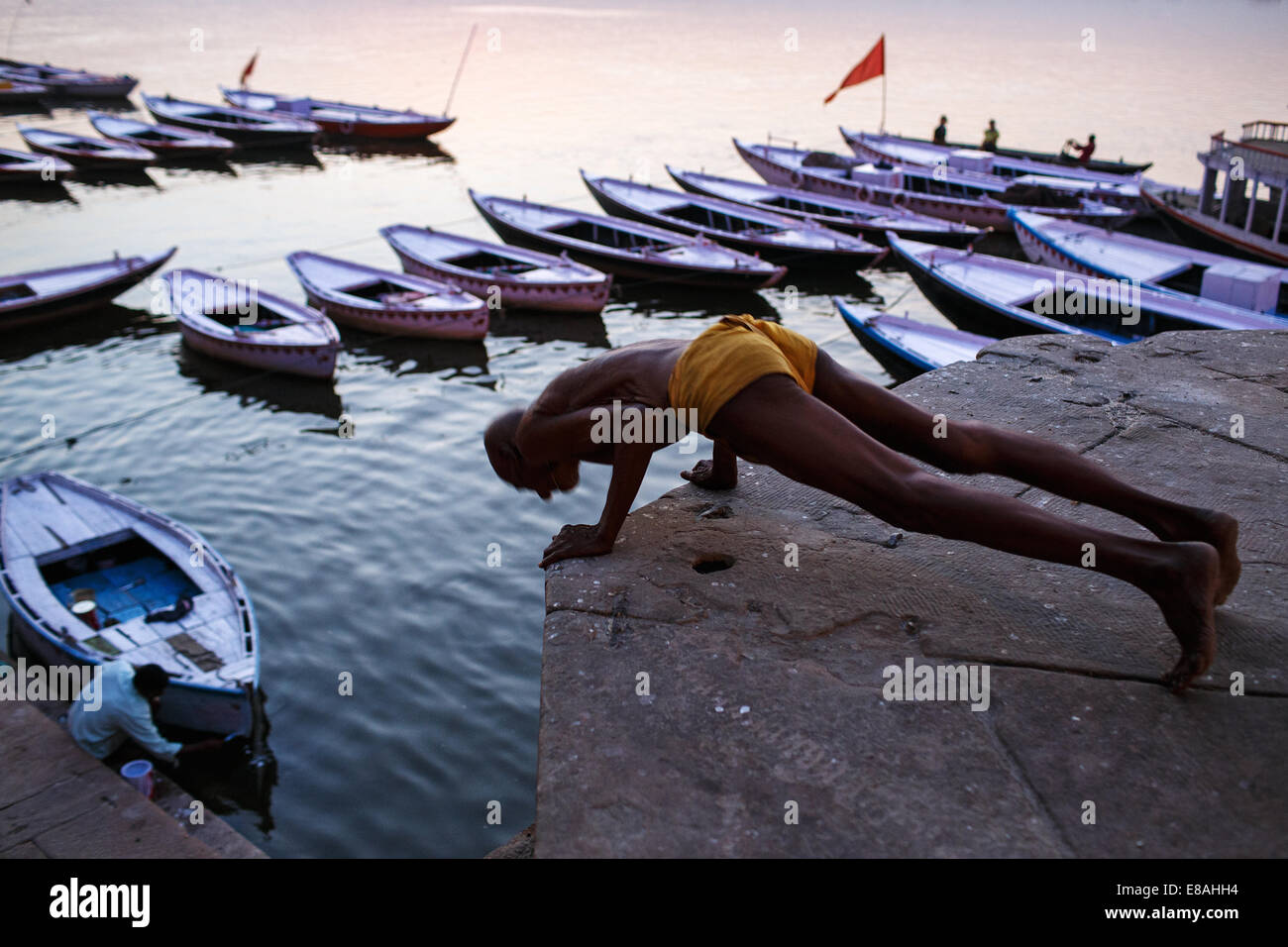 Man excercises at one of the Ganges ghats in Varanasi, India. Stock Photo