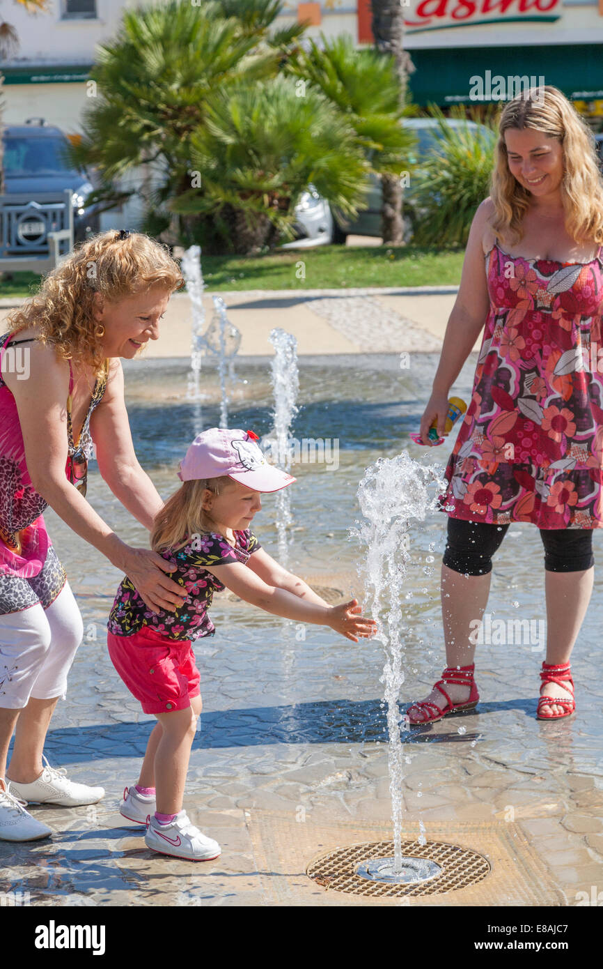 Girl playing in water fountain hi-res stock photography and images - Alamy