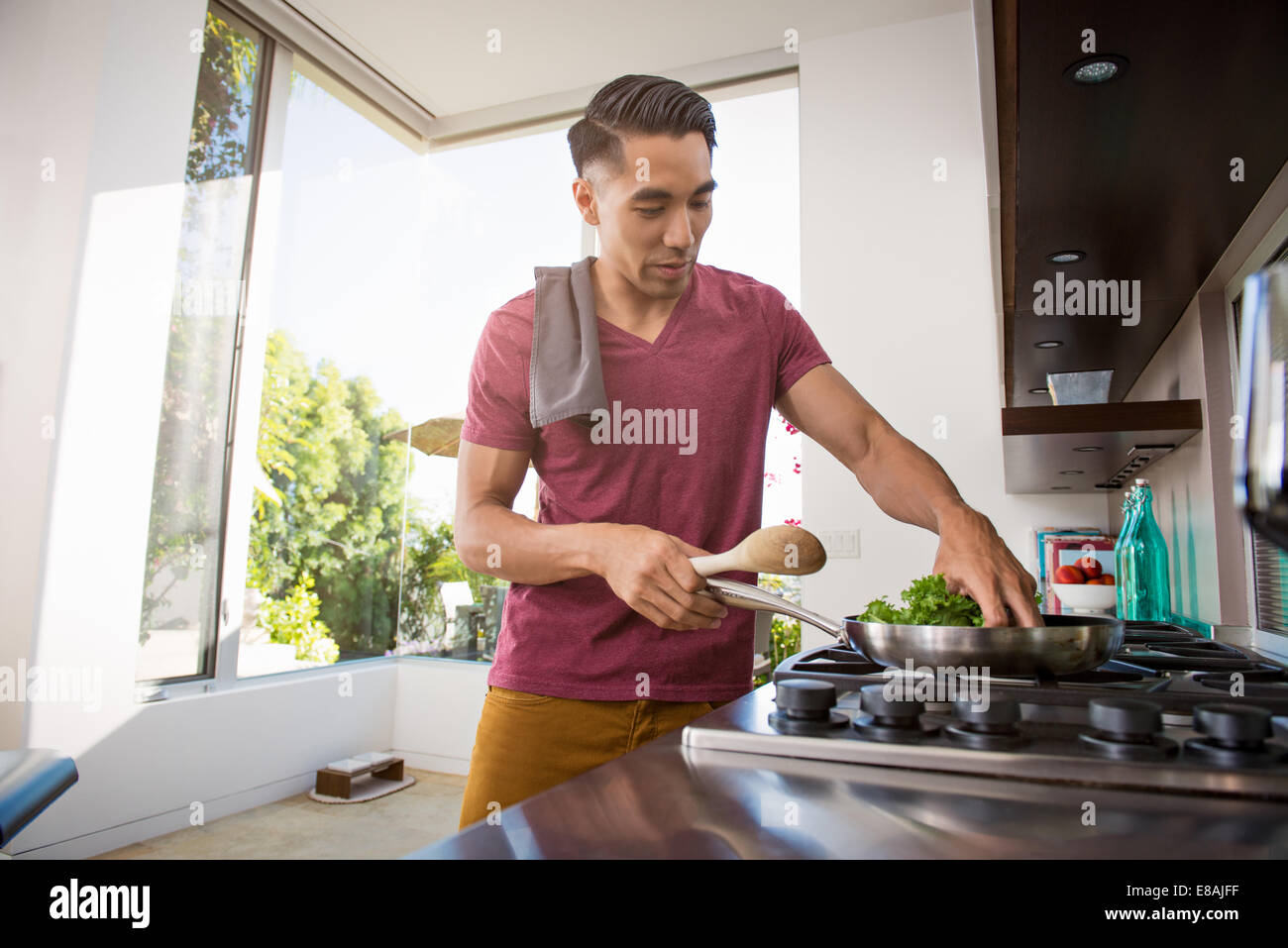 Young man cooking on hob in kitchen Stock Photo