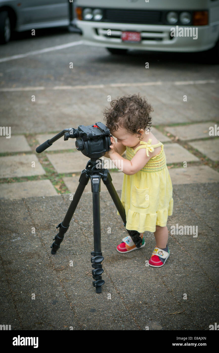 Cute baby girl playing with a tripod Stock Photo Alamy