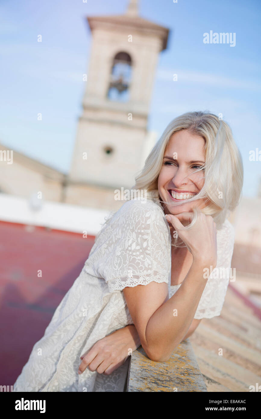 Woman on rooftop, bell tower in background Stock Photo