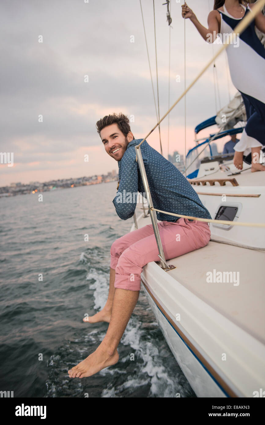 Mid adult man sitting on boat deck Stock Photo