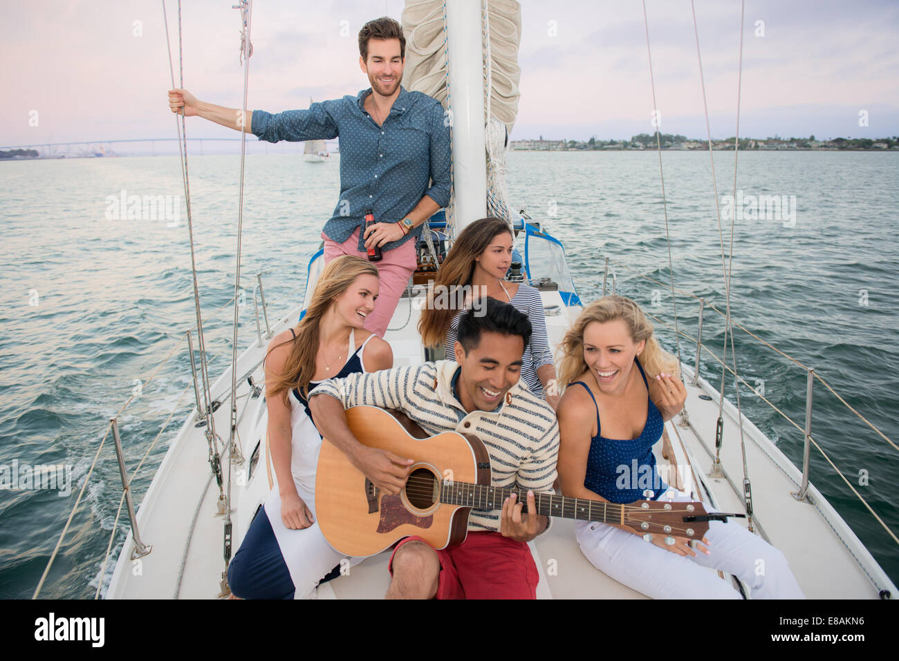 Friends on sailing boat, man playing guitar Stock Photo