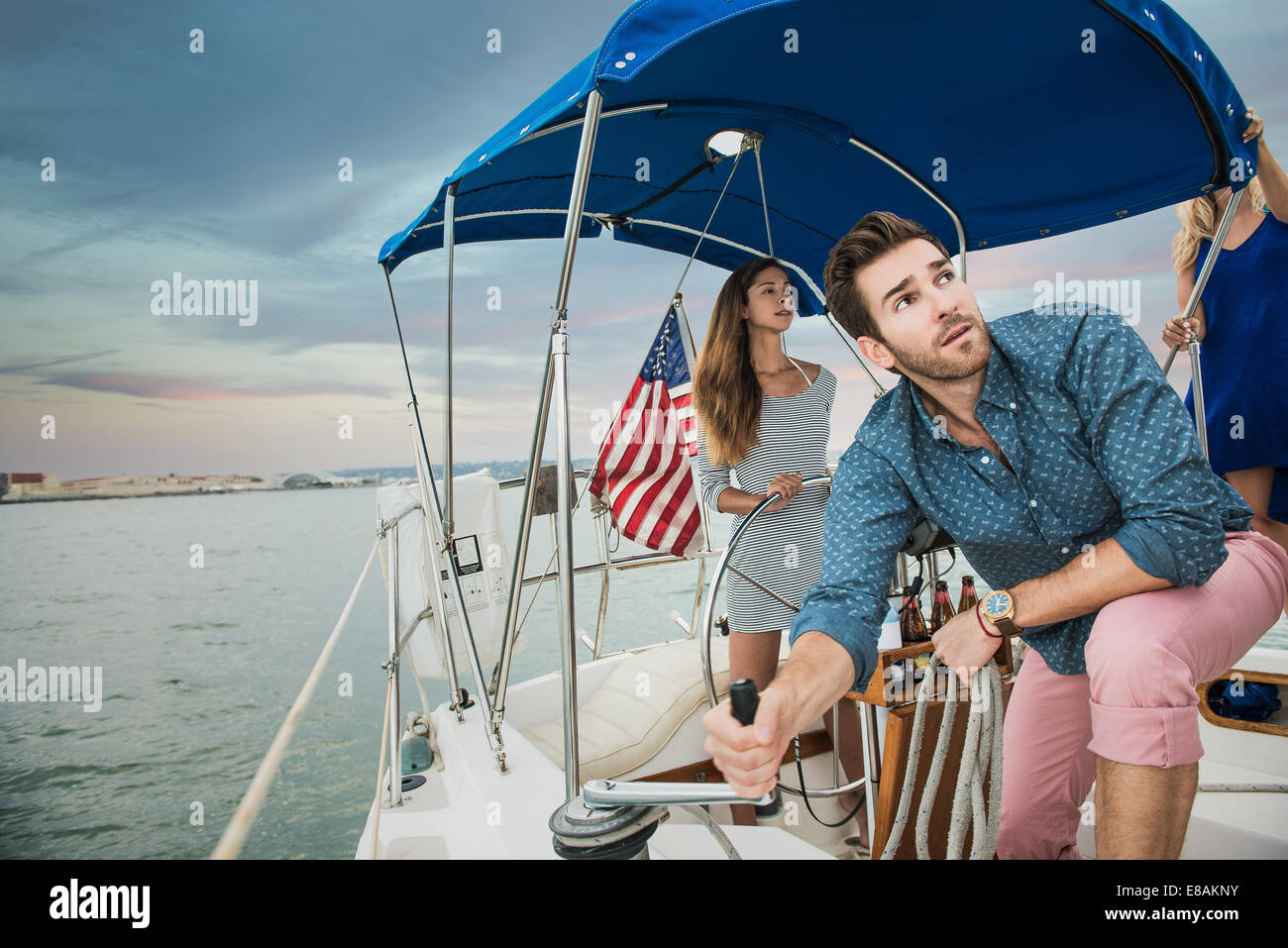 Mid adult man using winch on sailing boat Stock Photo