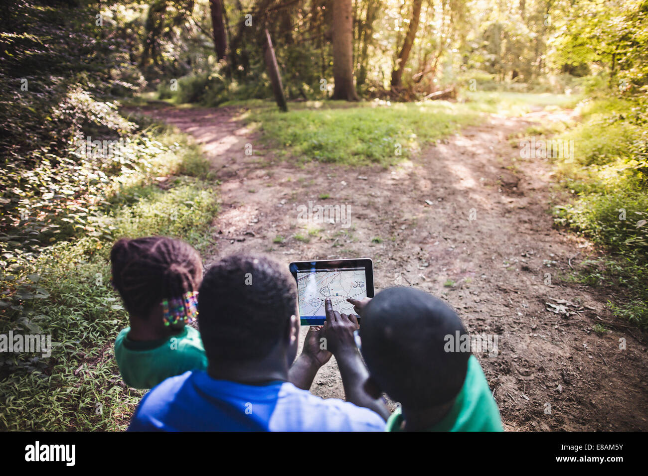 Father with daughter and son navigating with digital tablet in forest eco camp Stock Photo