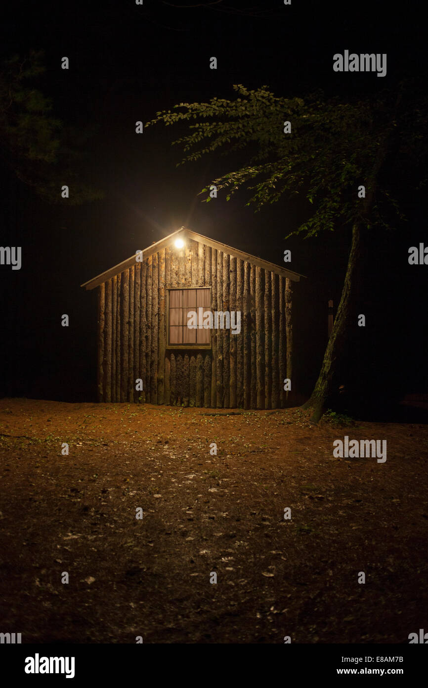 Wooden shed with electric light at night Stock Photo
