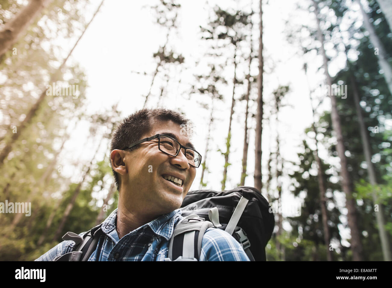 Hiker in forest wearing glasses, smiling Stock Photo