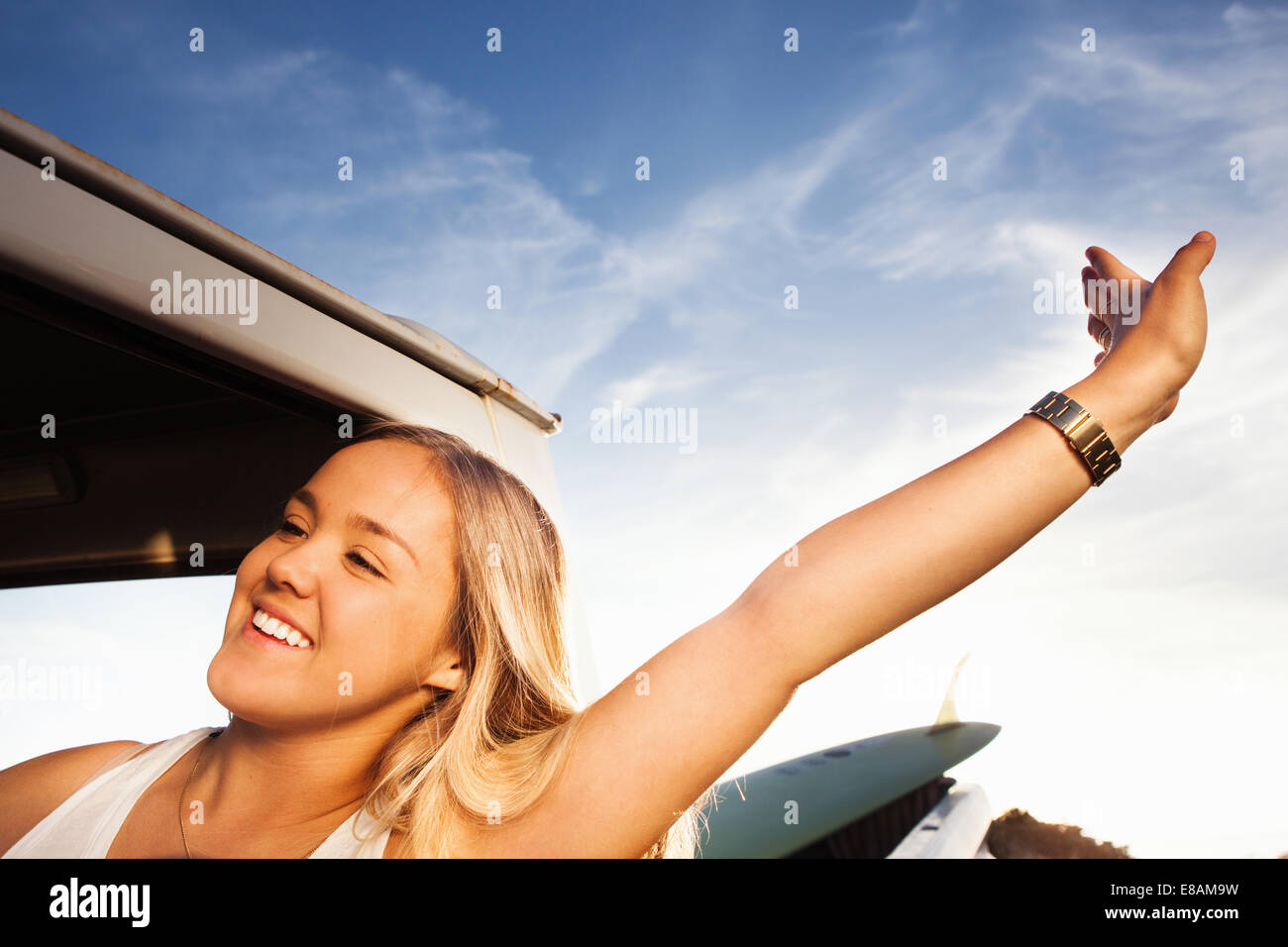 Young female surfer stretching next to pickup truck Stock Photo