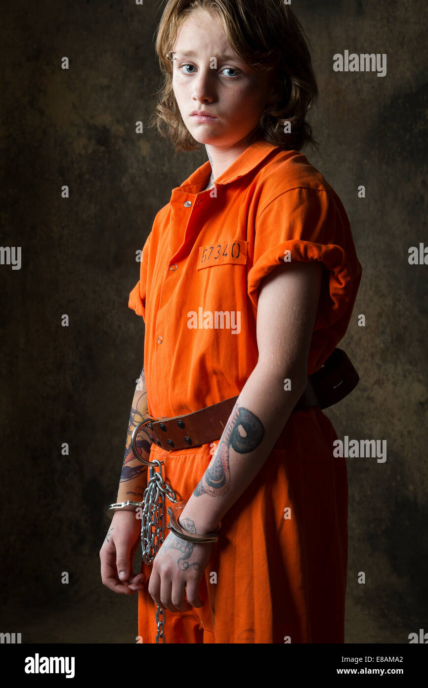 Studio portrait of sad boy in handcuffs and chains Stock Photo