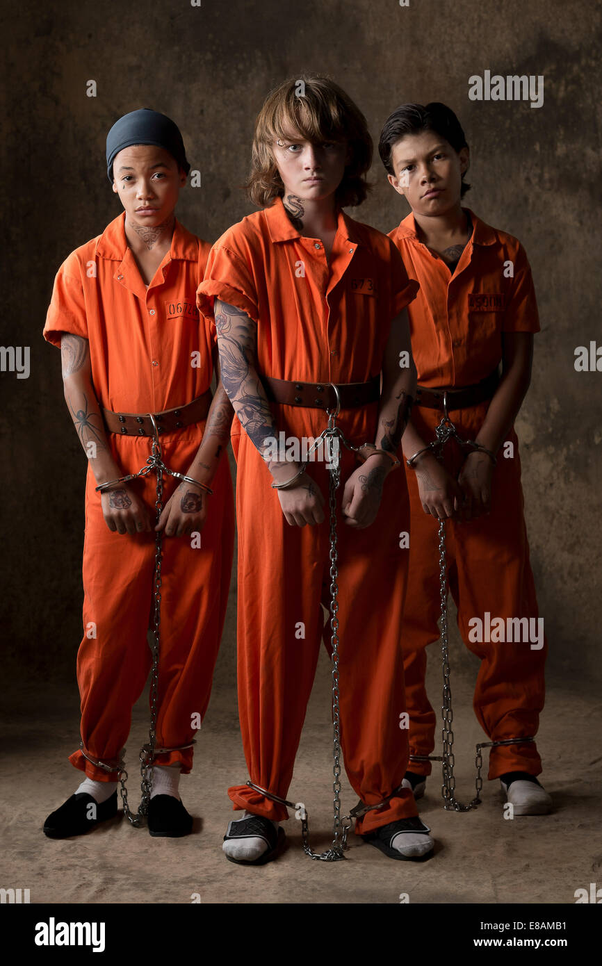 Studio portrait of three boys in handcuffs and chains Stock Photo