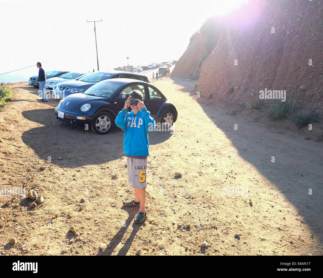 A young boy takes a picture from a along the coast road in California from a photo advantage point Stock Photo