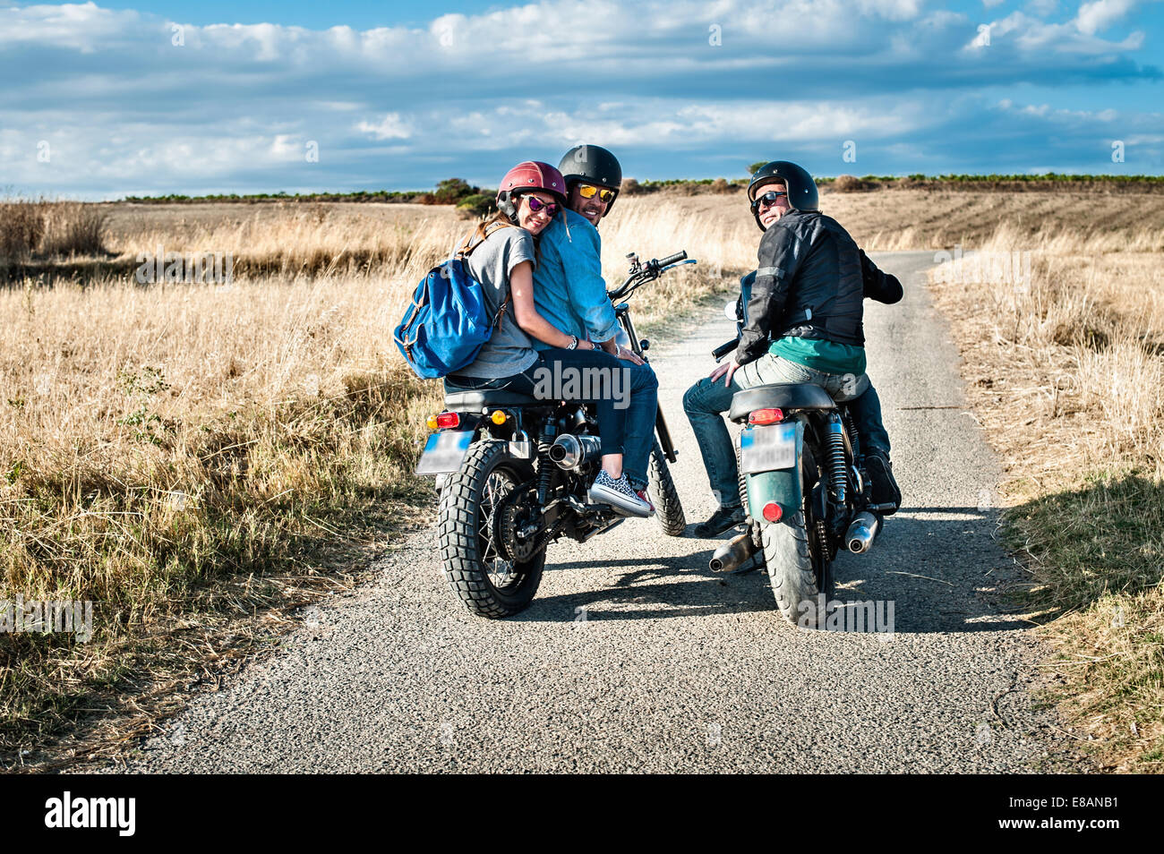 Rear view of three friends on motorcycles on rural road, Cagliari, Sardinia, Italy Stock Photo