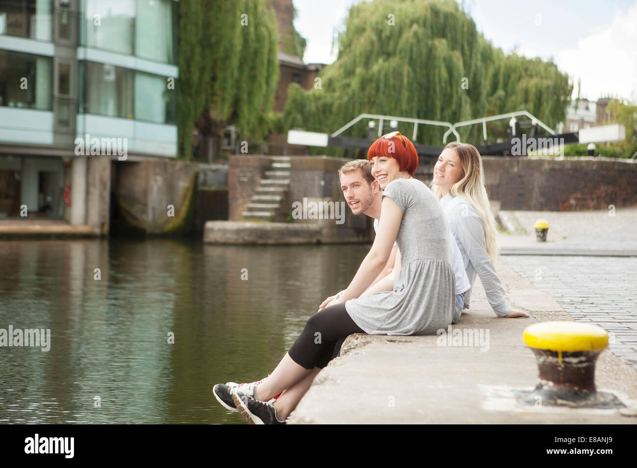 Friends sitting on canal side, East London, UK Stock Photo Alamy