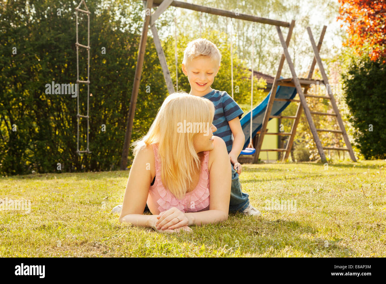 Mother and son in garden, swings in background Stock Photo