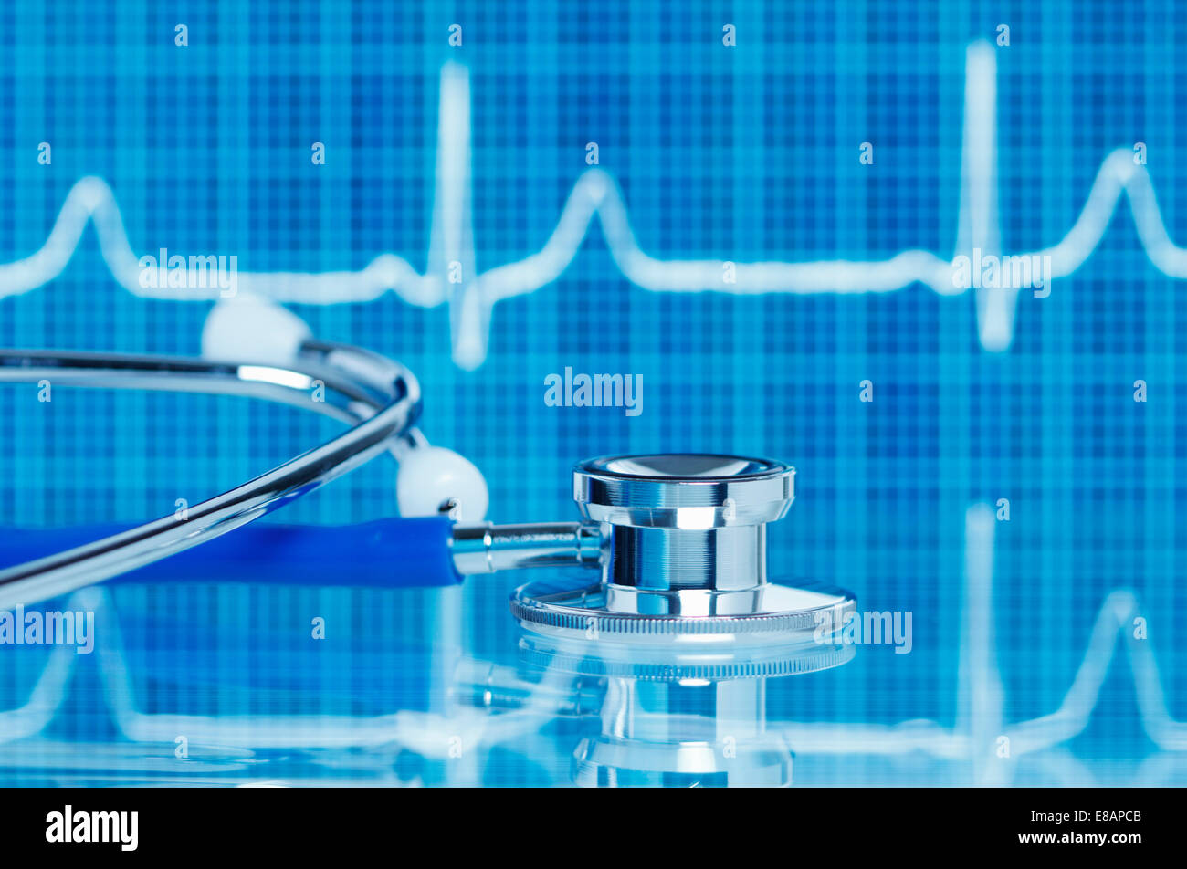 Acoustic stethoscope in front of electrocardiogram (pulse trace) displayed on a digital tablet screen Stock Photo