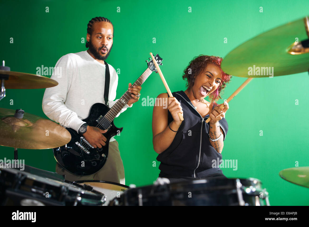 Students playing guitar and drums in college music room Stock Photo