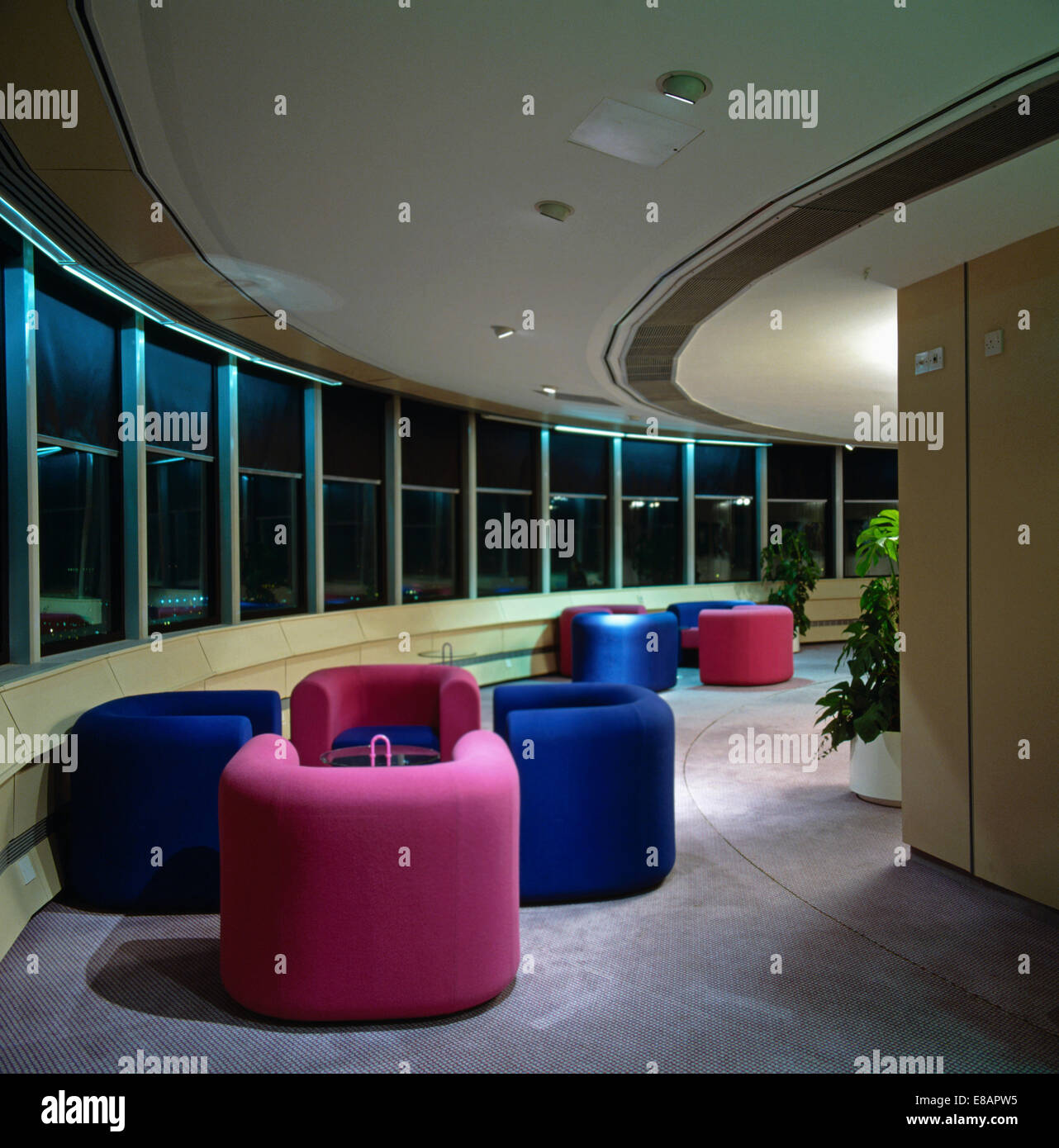 Bright pink and cobalt blue armchairs in meeting area in city office Stock Photo