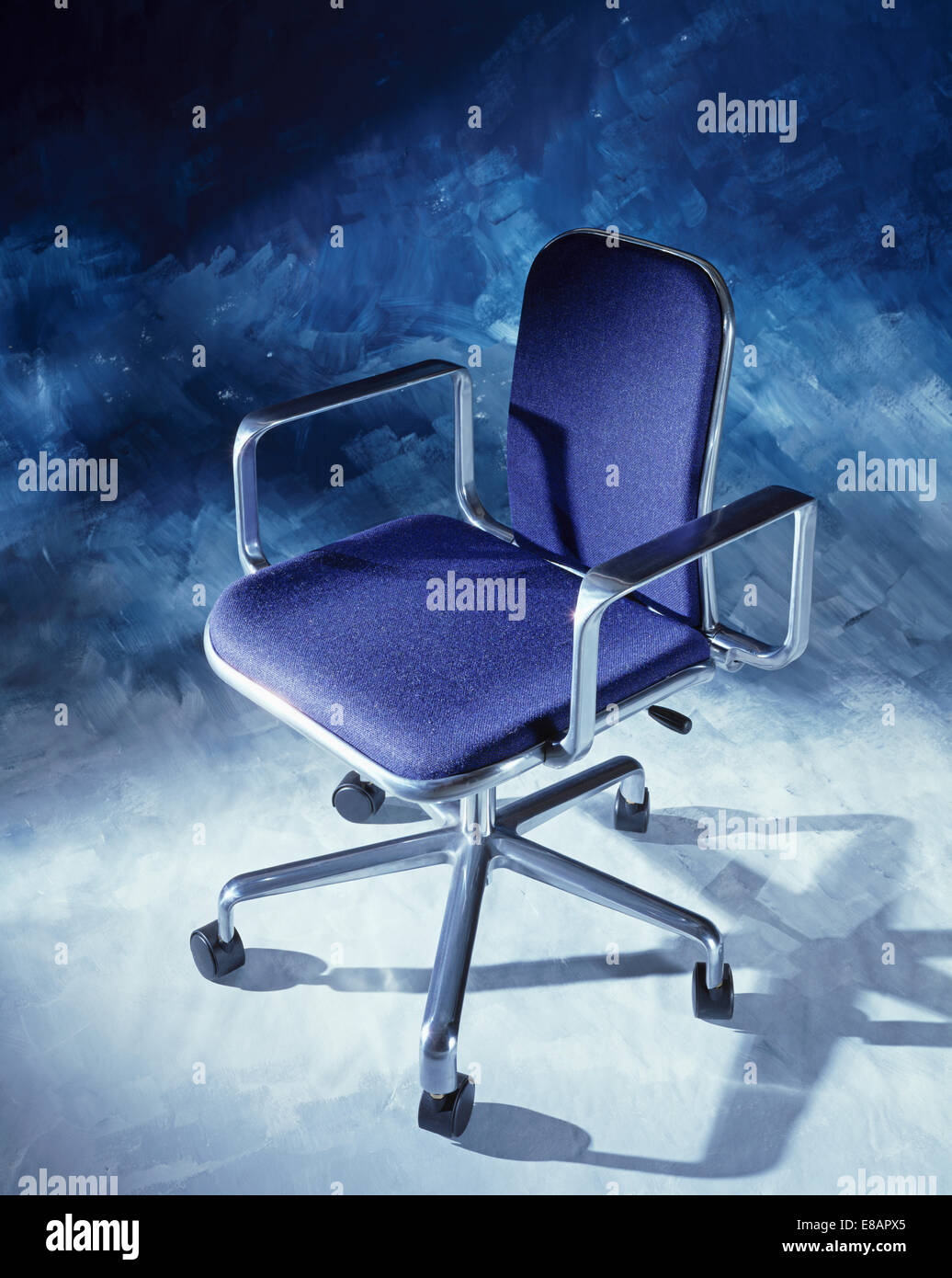 Stainless steel swivel office chair with dark blue upholstered seat *** Local Caption *** Close-up of stainless steel office cha Stock Photo