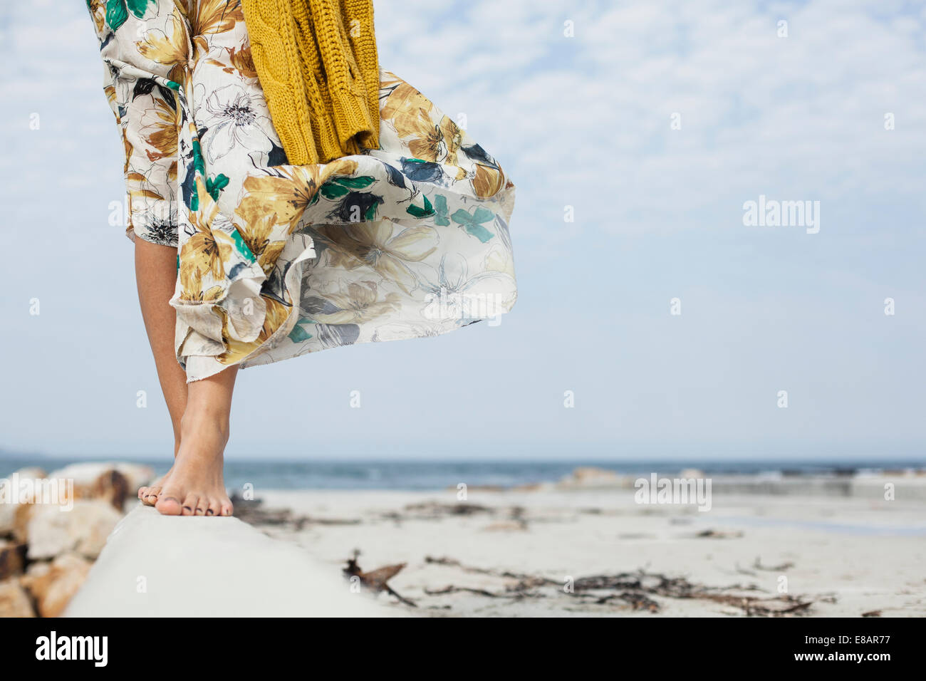 Young womans legs walking along cement block on beach, Cape Town, Western Cape, South Africa Stock Photo