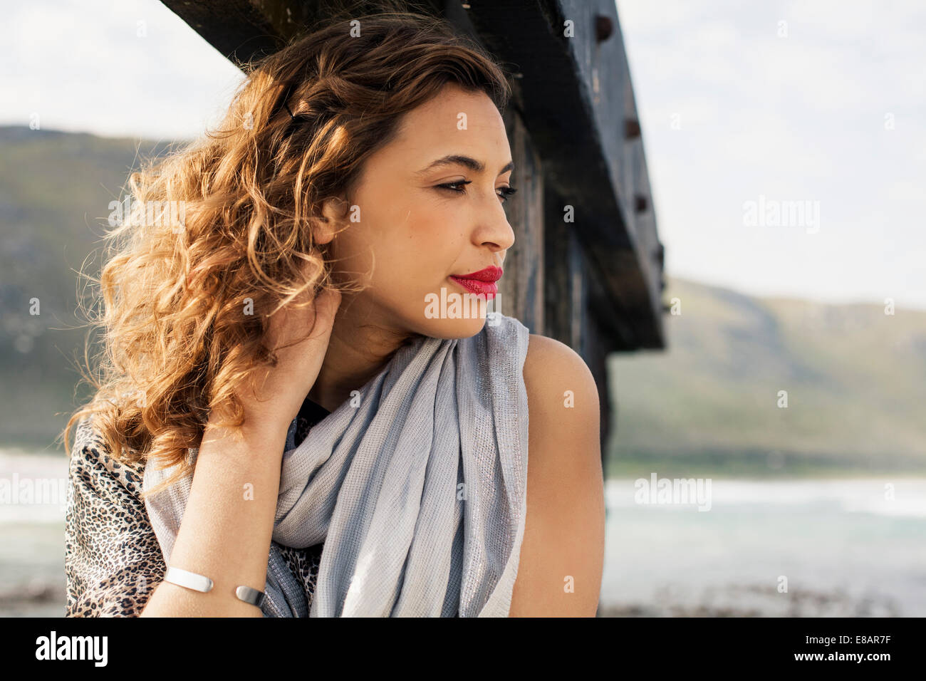 Young woman daydreaming on coastal pier, Cape Town, Western Cape, South Africa Stock Photo