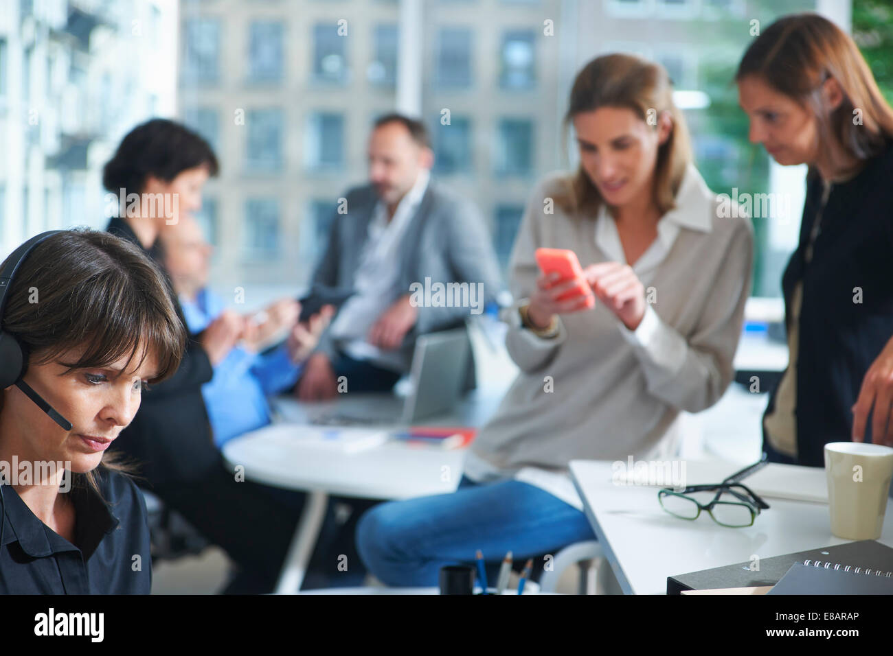Six businesswomen and men busy working in office Stock Photo