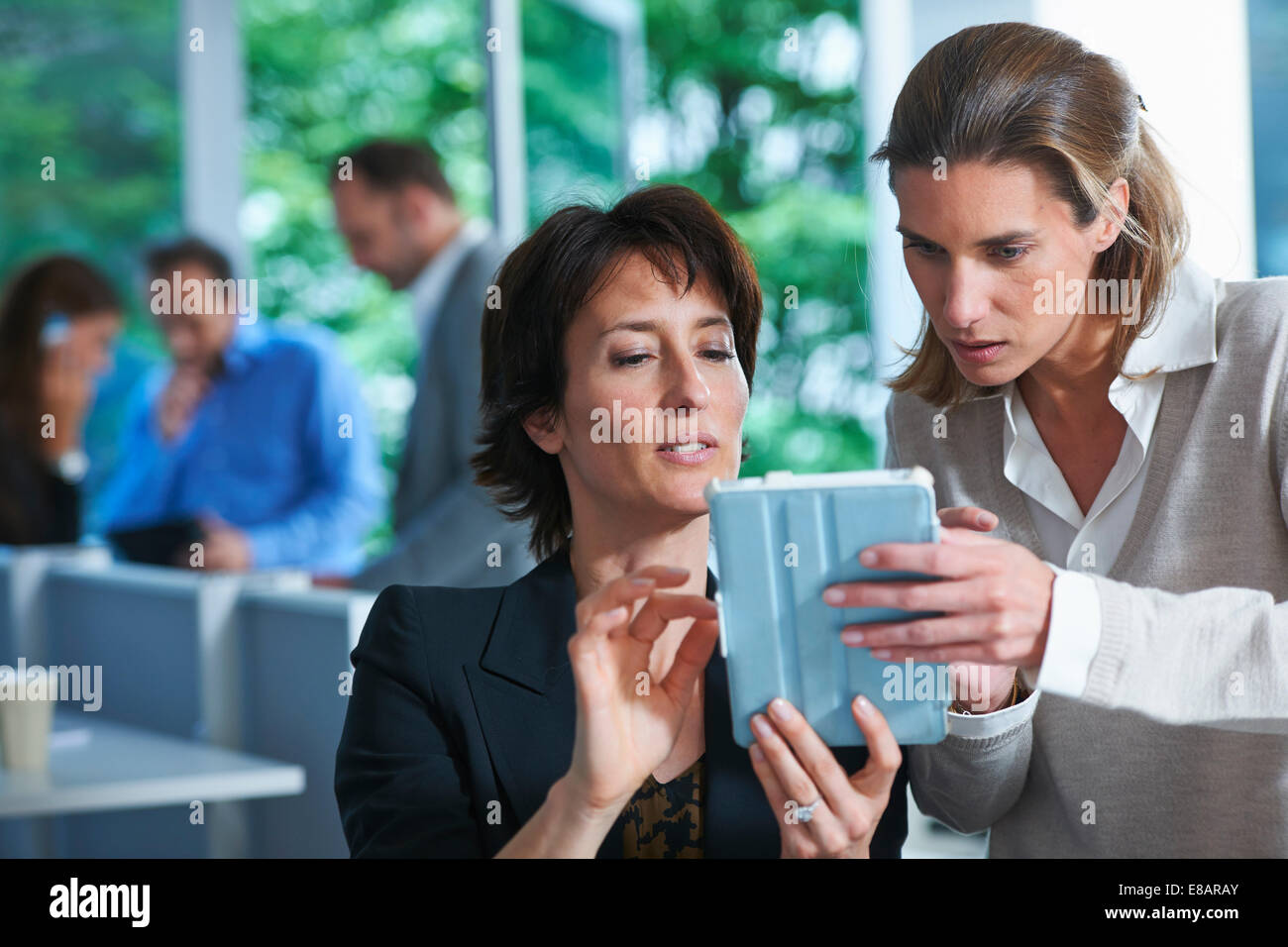 Two business women looking at digital tablet in office Stock Photo