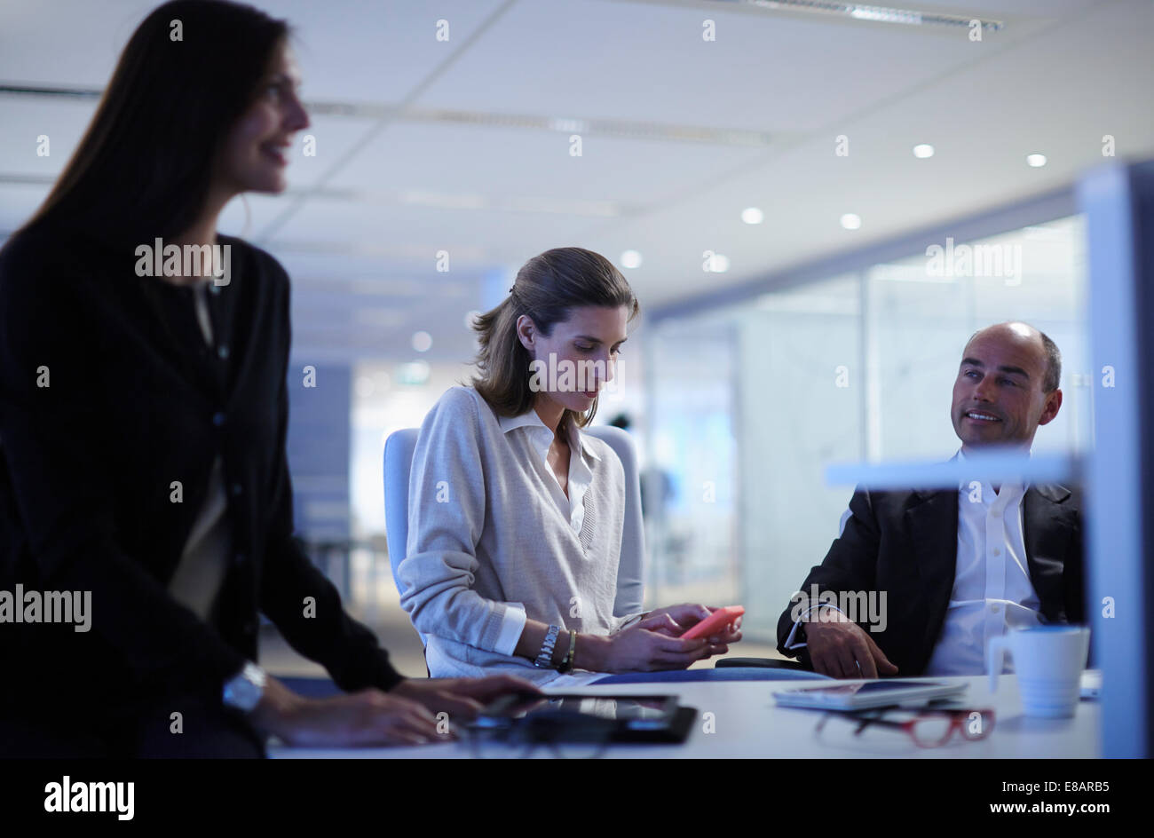 Business colleagues chatting over desk in office Stock Photo