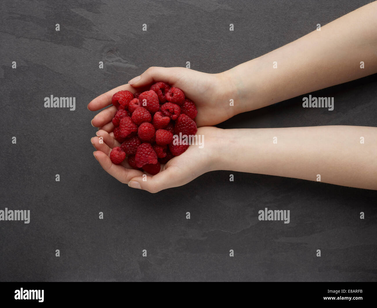 Hands holding fresh raspberries Stock Photo