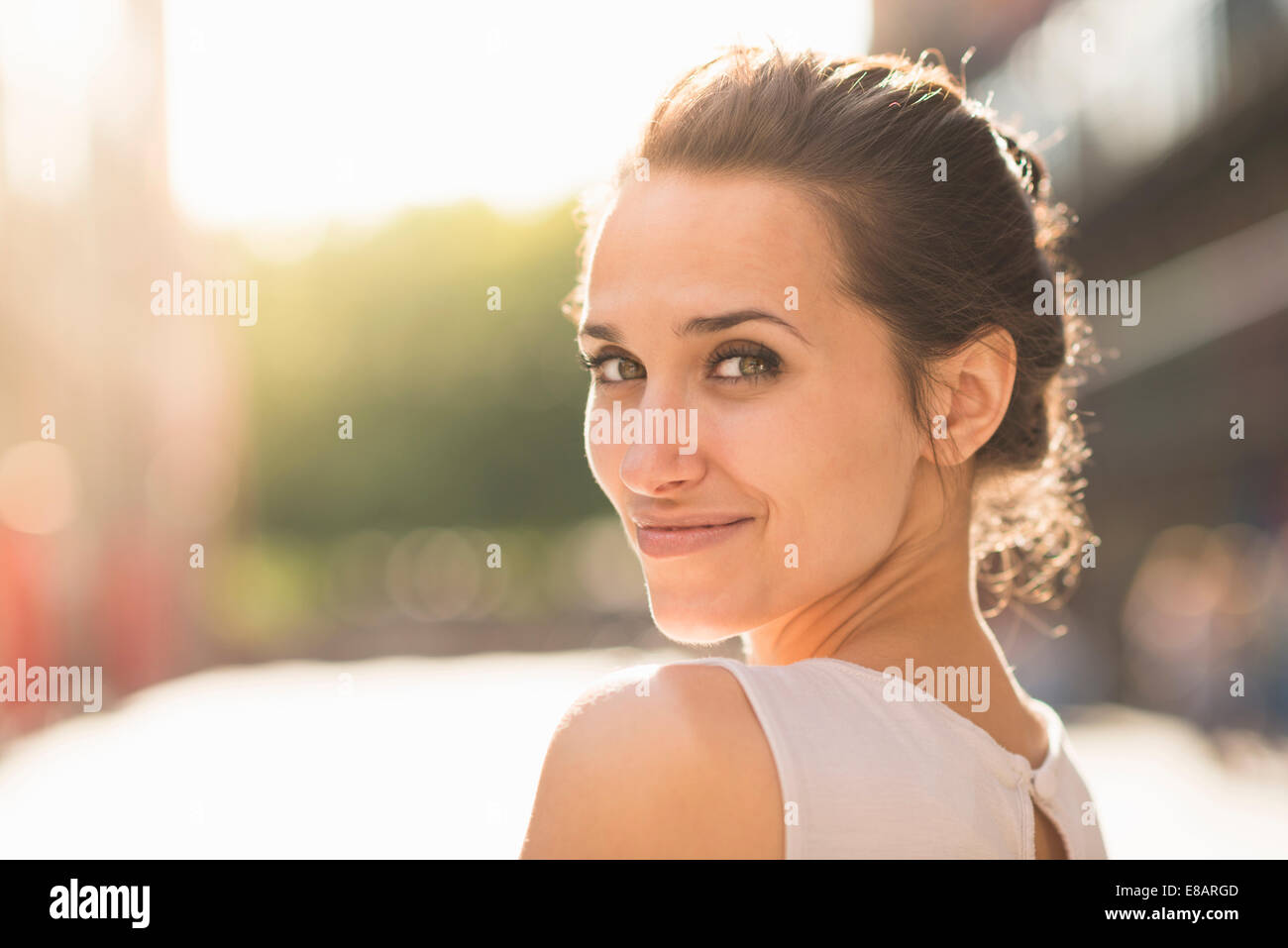 Young woman looking over shoulder towards camera Stock Photo