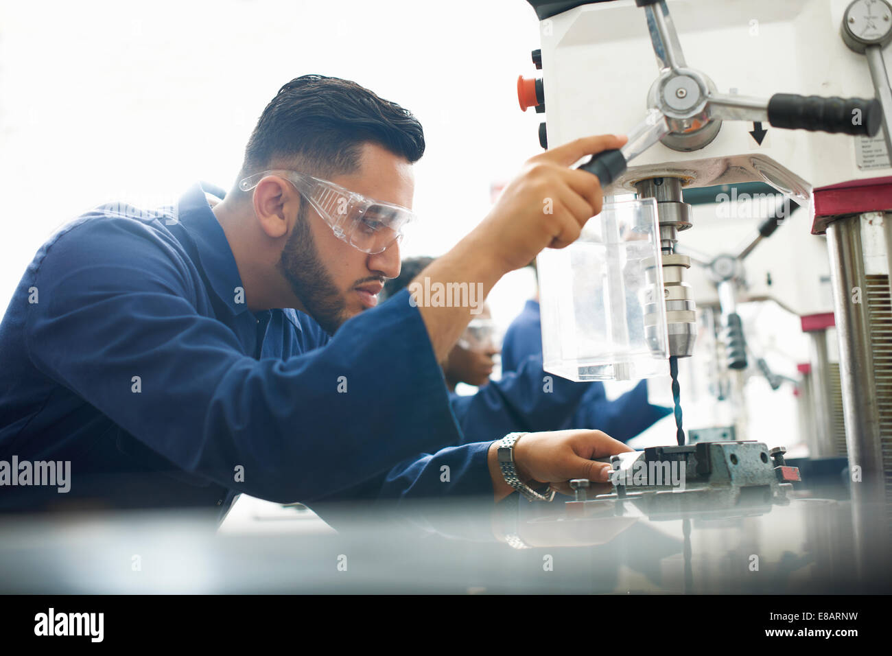 Male student using drilling machine in college workshop Stock Photo