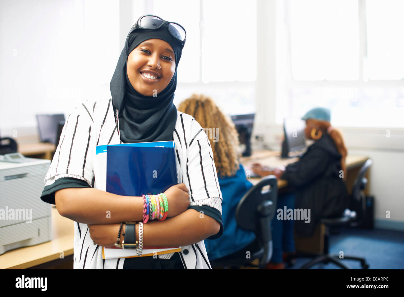 Portrait of young female student with file in college classroom Stock Photo