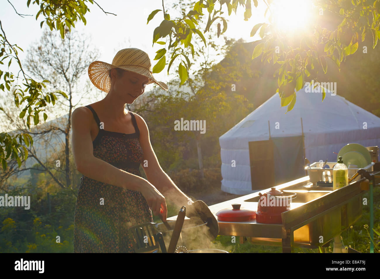 Young woman cooking food whilst glamping, Sierra Nevada, Andalucia Granada, Spain Stock Photo