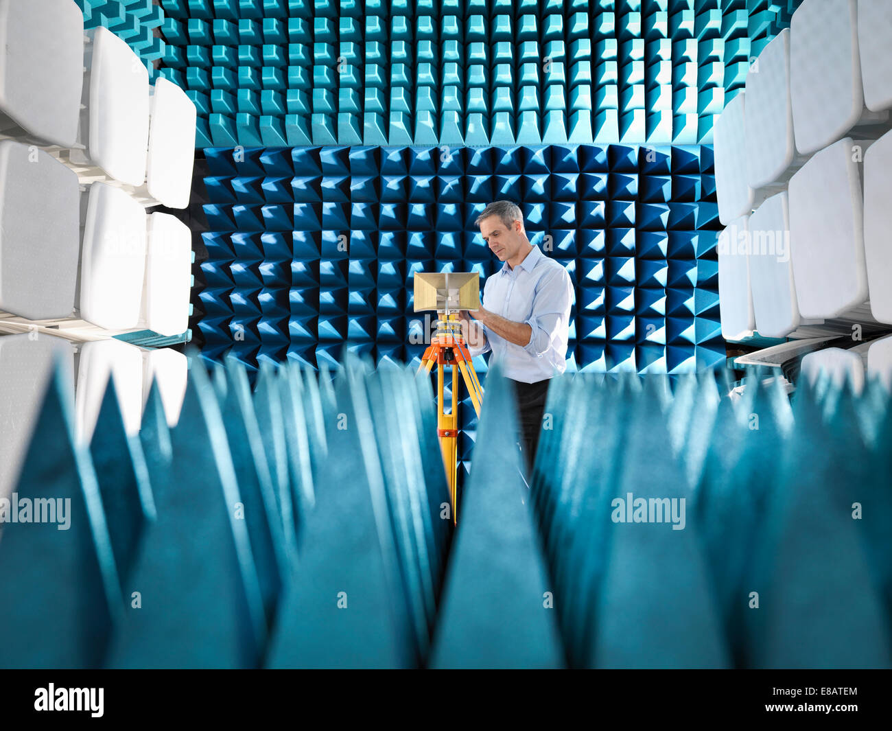 Male scientist preparing to measure electromagnetic waves in anechoic chamber Stock Photo