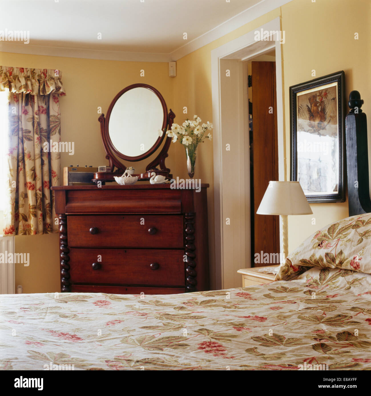 Oval Mirror On Mahogany Chest Of Drawers In Pale Yellow Country