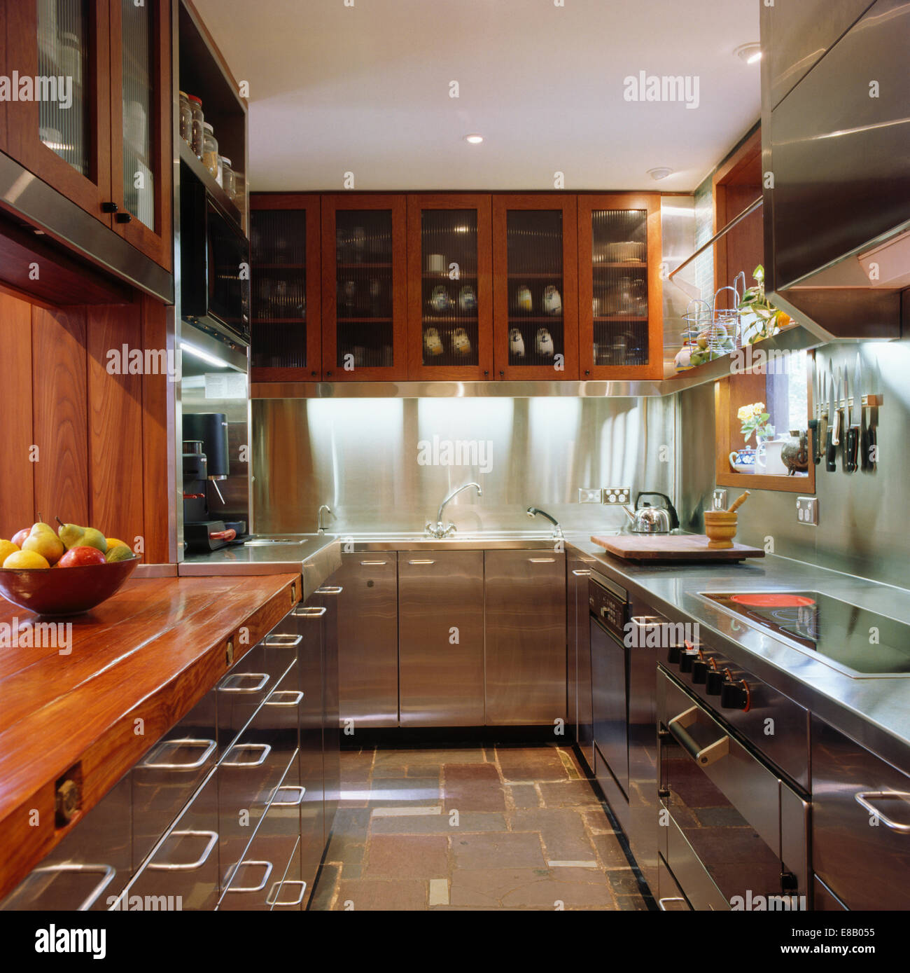 Stainless steel fitted units and splash back in modern galley kitchen ...