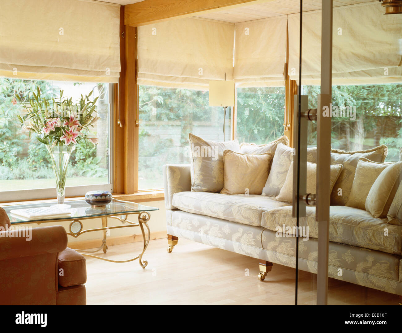 Glass doors open to modern conservatory living room extension with