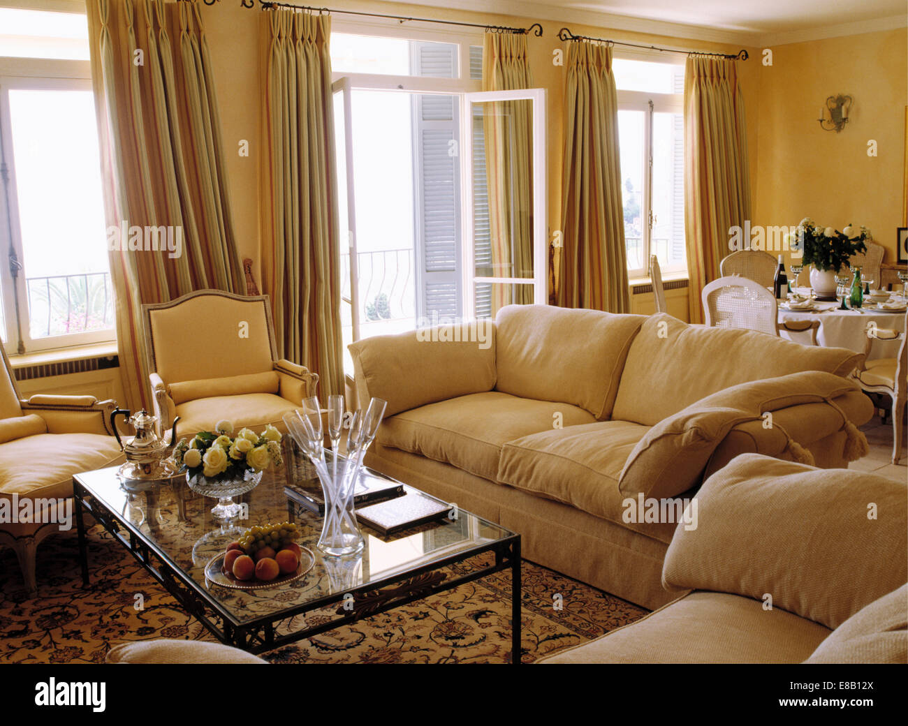 Cream sofas and windows with heavy linen curtains in yellow French