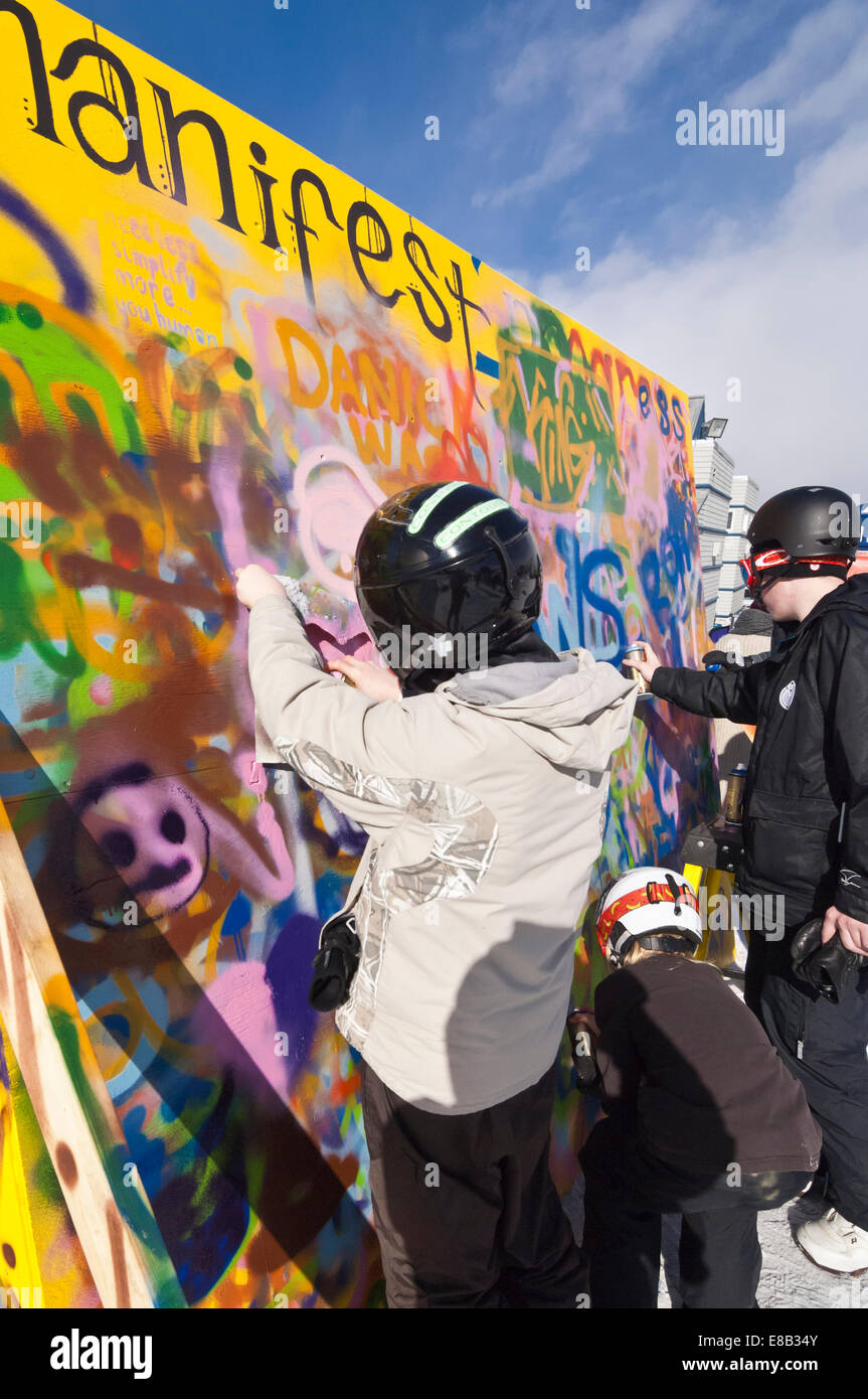 Young snowboarders and skiers spraying paint, graffiti, onto a board at Canada Olympic Park, Calgary, Alberta, Canada Stock Photo