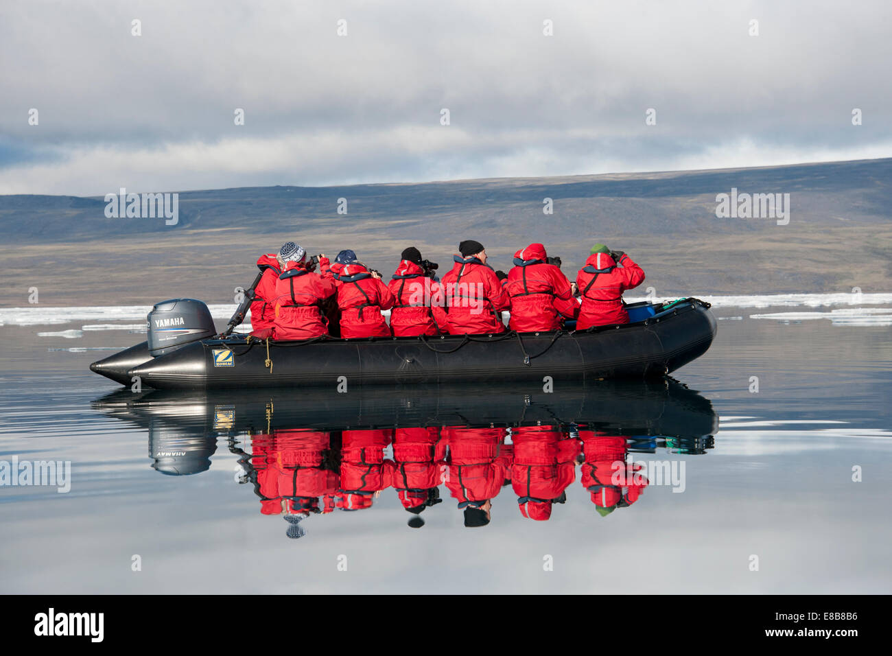 Zodia full of eco-tourists, with reflection, Baffin Island, Canada, Arctic Ocean. Stock Photo