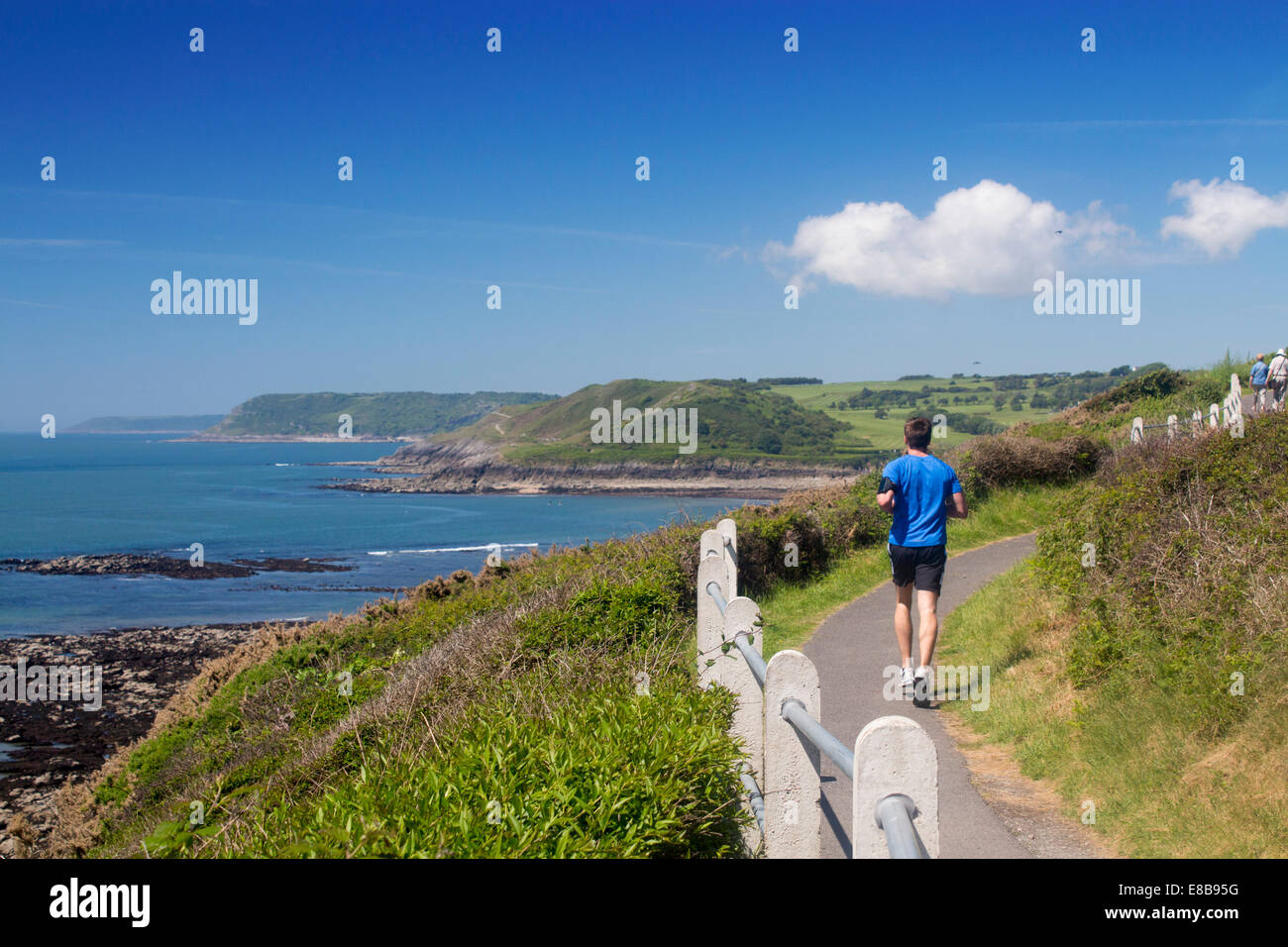 Runner jogger on Wales Coast Path near Langland Bay Gower Peninsula Swansea County South Wales UK Stock Photo