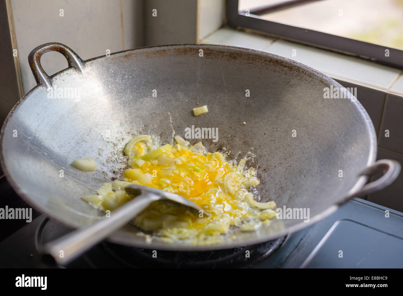 Asian style stir fry eggs and onions cooking in a wok Stock Photo Alamy