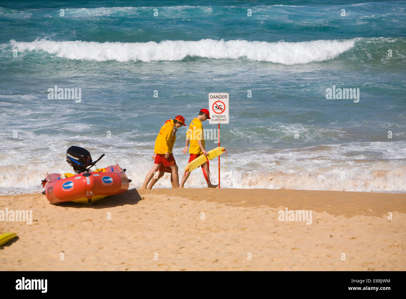 two surf rescue life savers teenage boys on manly beach,sydney,australia walking past danger strong currents sign Stock Photo