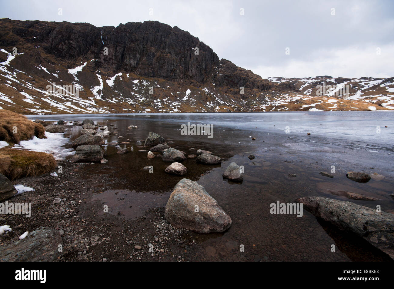Pavey Ark, behind a frozen Stickle Tarn in the Lake District National Park. Stock Photo