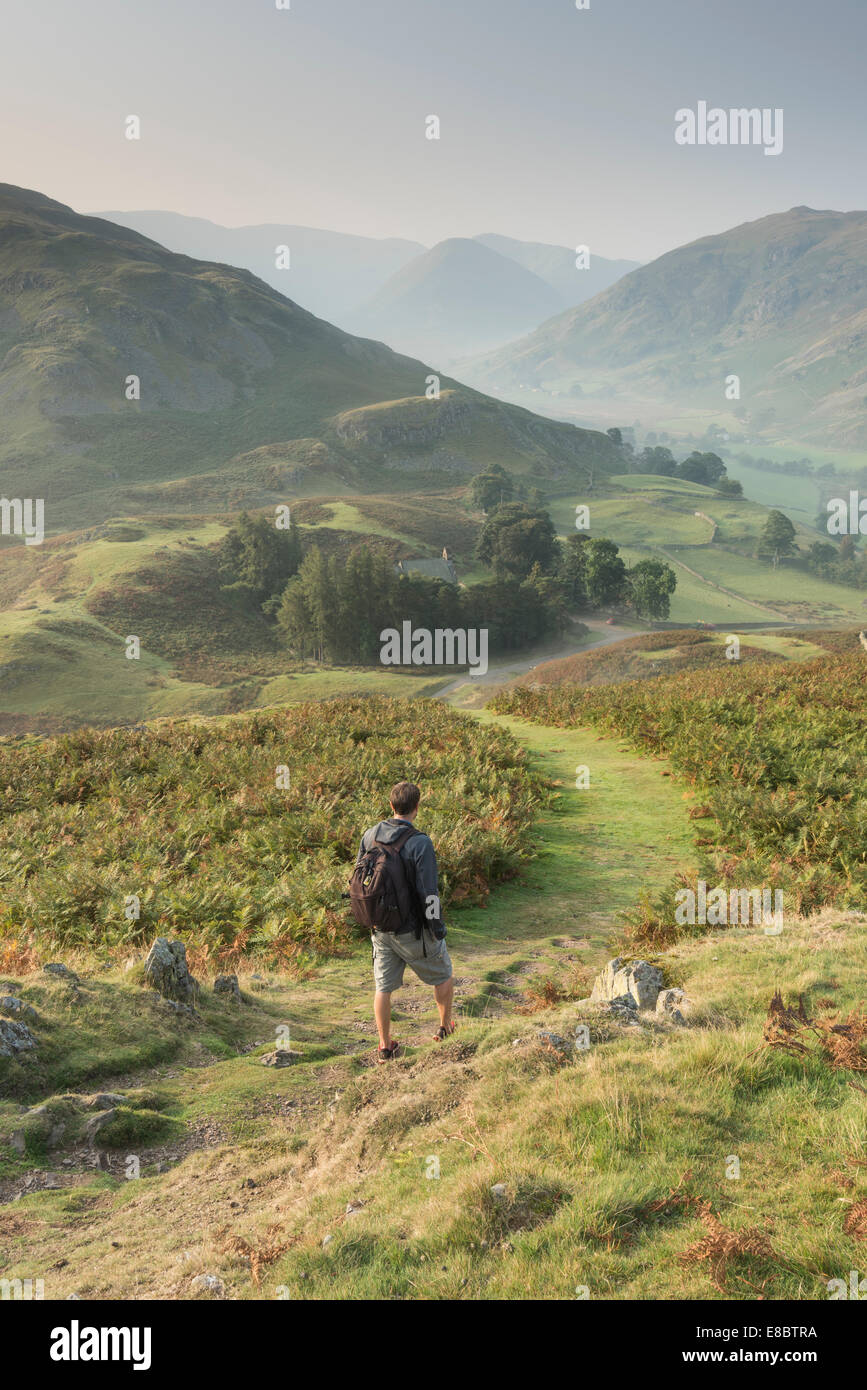 Walker on Hallin Fell in autumn in the English Lake District, with Martindale, Beda Head and the Nab beyond Stock Photo