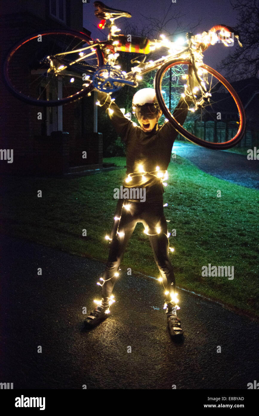 Christmas Tree Cyclist with LED lighting at night. Stock Photo