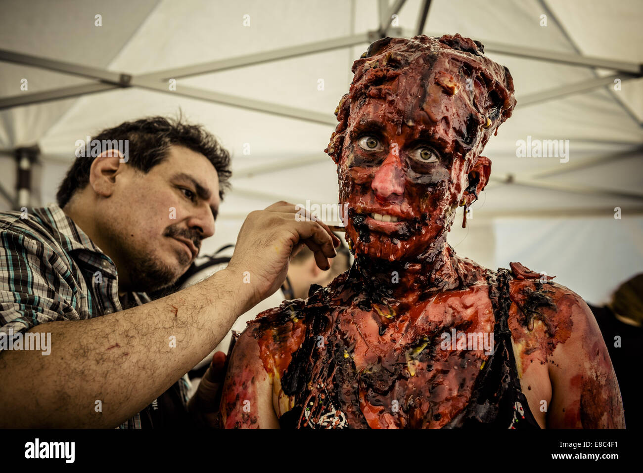 Sitges, Spain. 4th Oct, 2014. A makeup artist remodels the zombie makeup of a woman taking part in the Sitges Zombie Walk 2014 Credit:  Matthias Oesterle/ZUMA Wire/ZUMAPRESS.com/Alamy Live News Stock Photo