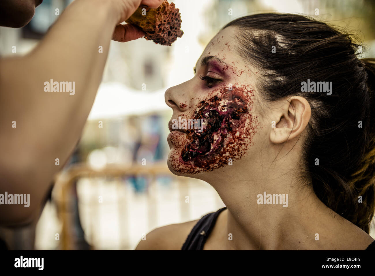 Sitges, Spain. 4th Oct, 2014. A makeup artist puts a zombie makeup on a woman's face for the Sitges Zombie Walk 2014 Credit:  Matthias Oesterle/ZUMA Wire/ZUMAPRESS.com/Alamy Live News Stock Photo