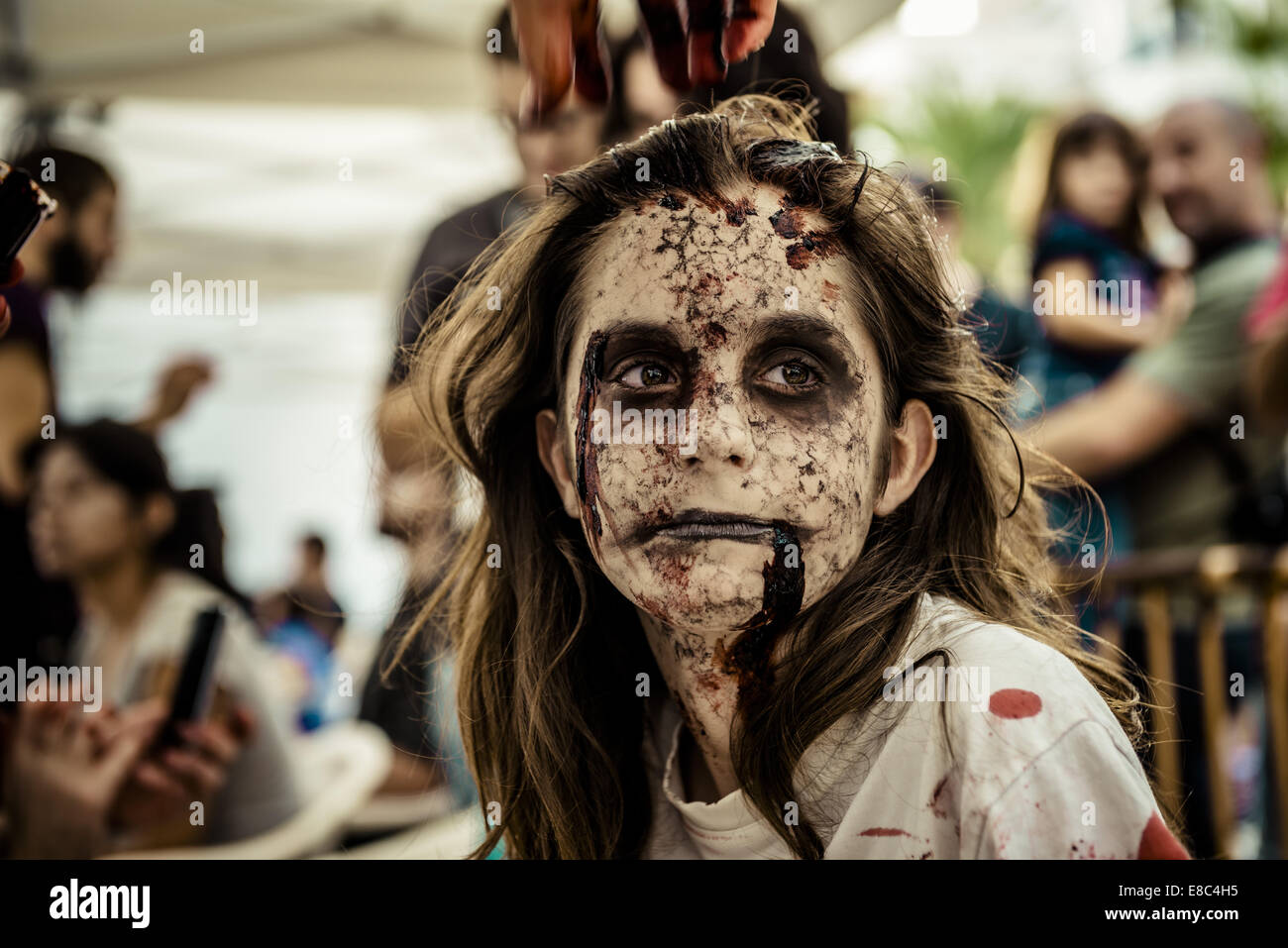 Sitges, Spain. 4th Oct, 2014. A makeup artist puts a zombie makeup onto a girl's face for the Sitges Zombie Walk 2014 Credit:  Matthias Oesterle/ZUMA Wire/ZUMAPRESS.com/Alamy Live News Stock Photo
