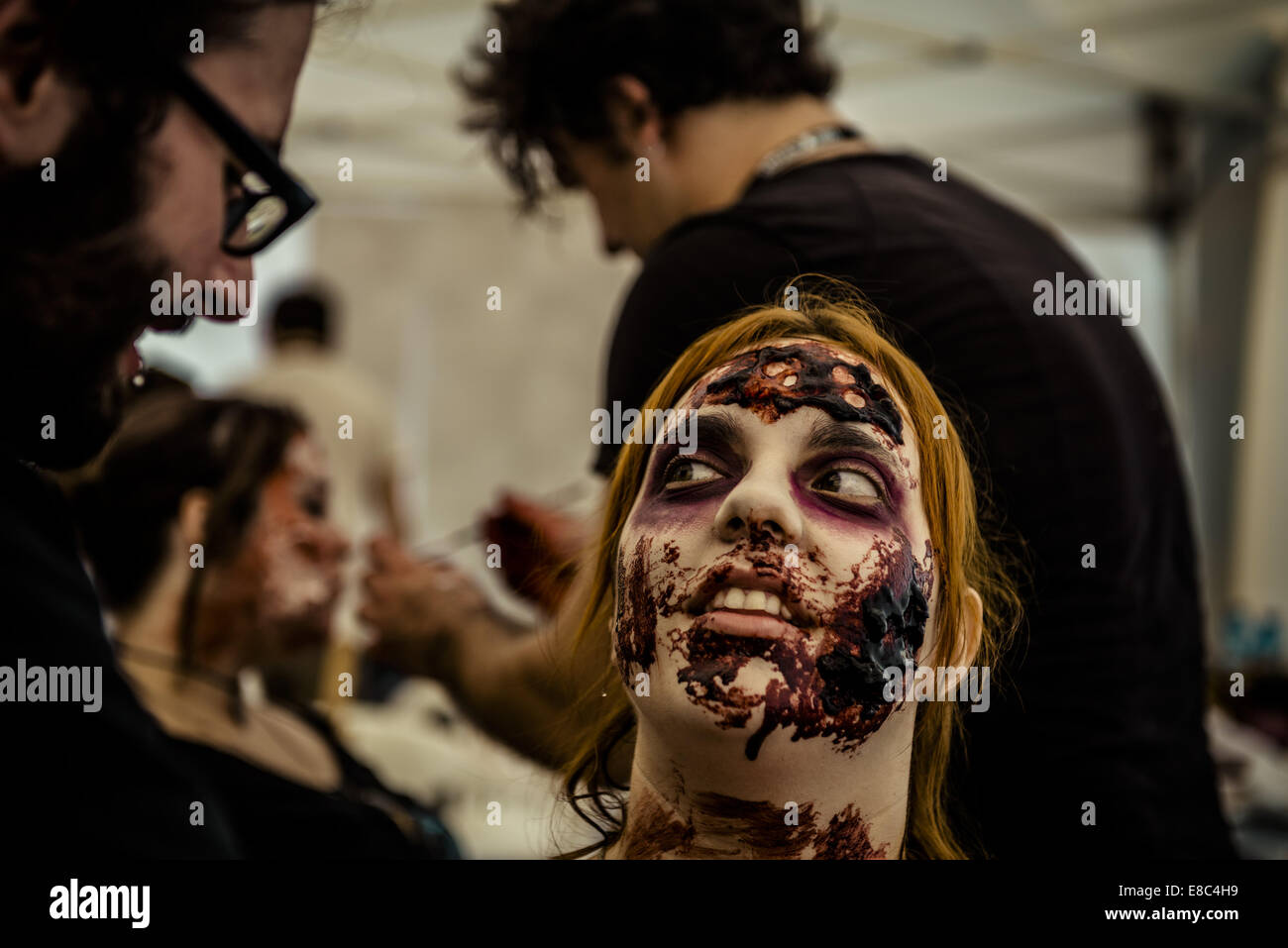 Sitges, Spain. 4th Oct, 2014. A makeup artist puts a zombie makeup on a woman's face for the Sitges Zombie Walk 2014 Credit:  Matthias Oesterle/ZUMA Wire/ZUMAPRESS.com/Alamy Live News Stock Photo