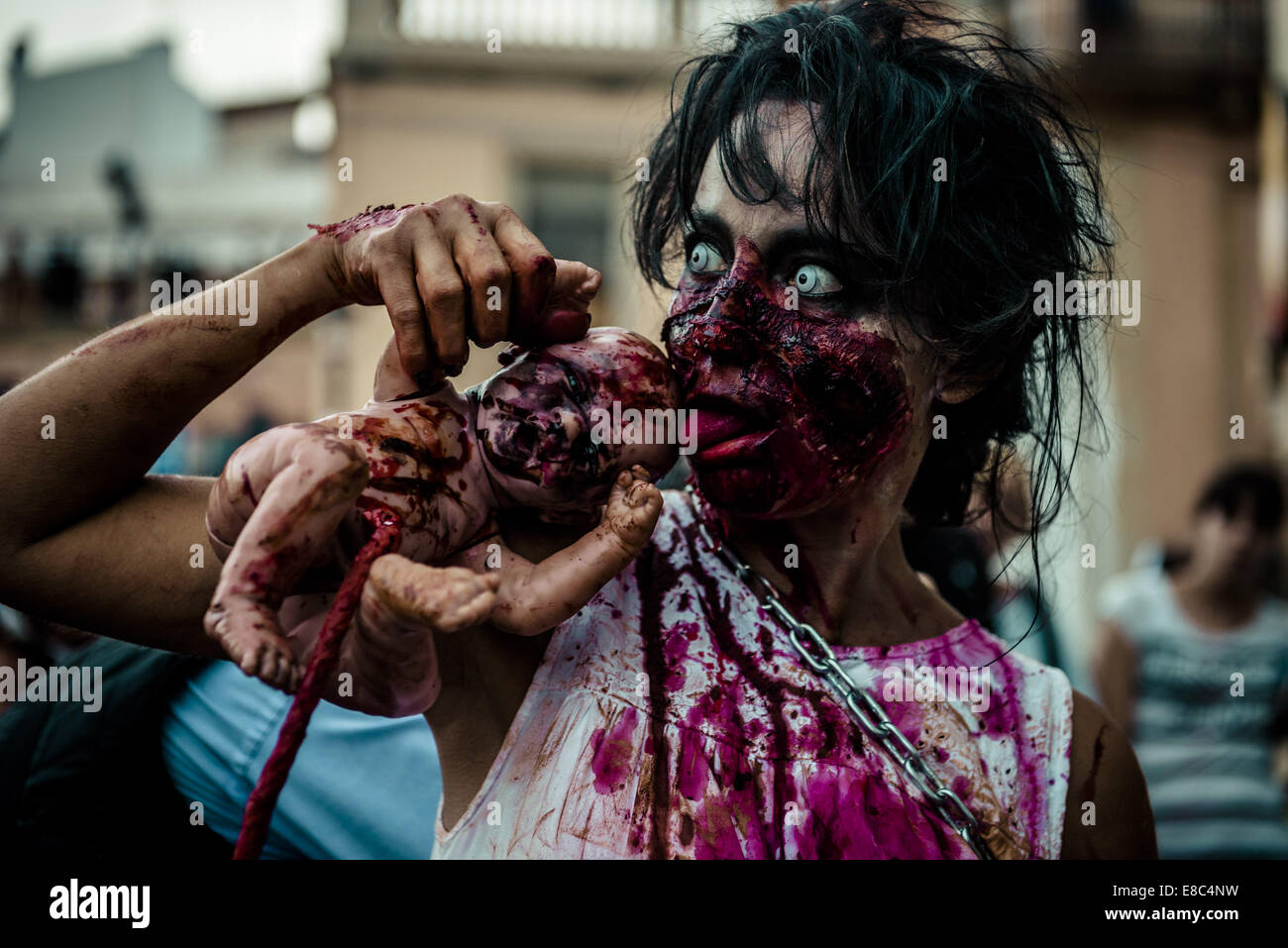 Sitges, Spain. 4th Oct, 2014. A woman in a zombie costume licks at her zombie puppet hanging on a umbilical cord at the Sitges Zombie Walk 2014 Credit:  Matthias Oesterle/ZUMA Wire/ZUMAPRESS.com/Alamy Live News Stock Photo